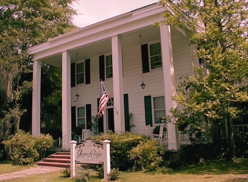 A picturesque white house with a large porch, the Gaines Ridge Dinner Club in Alabama is renowned for its hauntings
