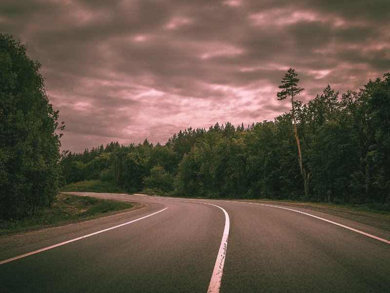 A hwy road flanked by trees and clouds, hinting at the ghostly tales of the Highway 5 Ghost in Lynn.