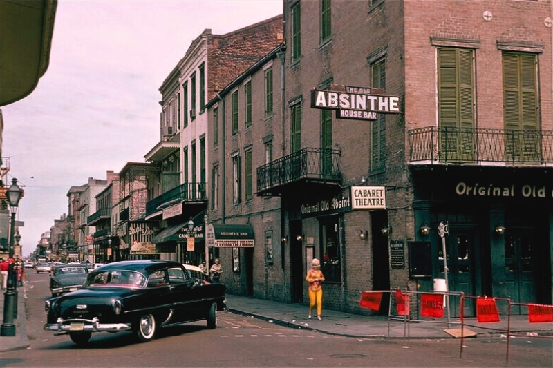 A classic vintage car stands in front of the Old Absinthe House, highlighting the charm of New Orleans' rich history.