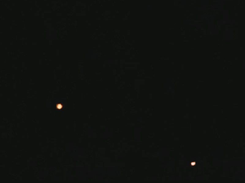 Two orange lights illuminate the dark sky, a mysterious phenomenon known as the Dover Lights in Arkansas' Ozark hills.