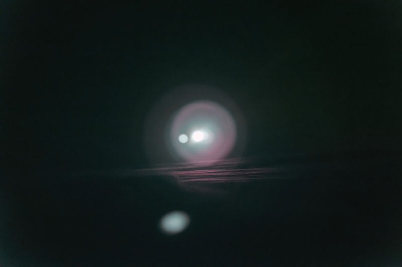 A captivating light emerges from a dark sky, illuminating the surroundings with a sense of mystery and wonder.