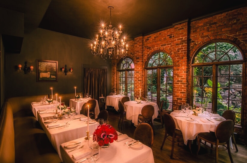 The elegant dining room of the haunted restaurant, One if by Land, Two if by Sea in New York, showcasing its charming ambiance and historic decor.