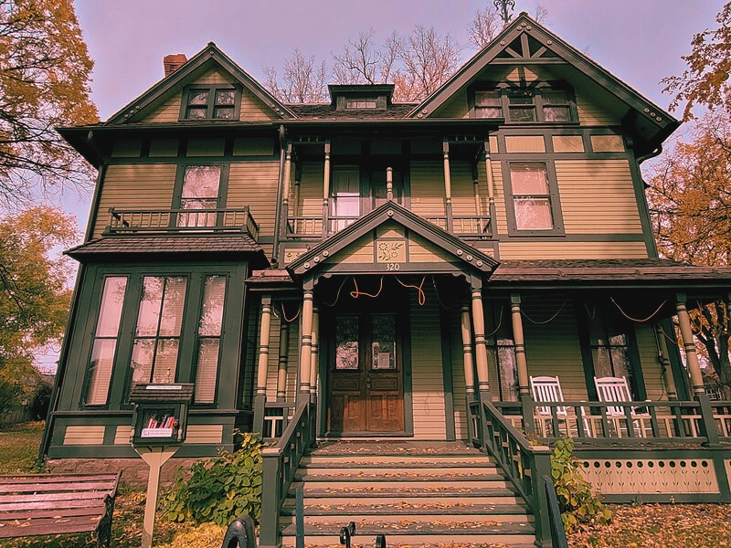 The Former Governors' Mansion in Bismarck, a green Victorian house featuring a porch and steps, built in 1884.