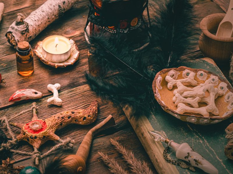 A wooden table filled with witchcraft tools and Obeah items, showcasing a mystical setting.