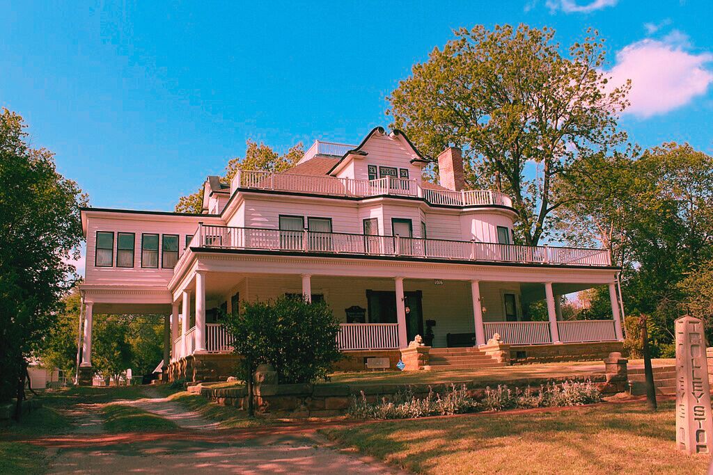 A large white house with a porch and a tree, the Stone Lion Inn, famous for being one of haunted.