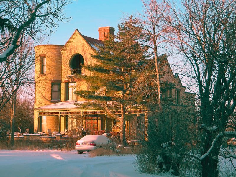 A large house, Easton Castle, with a car parked in front, noted as one of the most haunted places in South Dakota.
