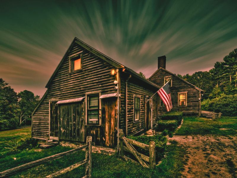 An American flag flutters in front of The Conjuring House, a historic and haunted site in Rhode Island.