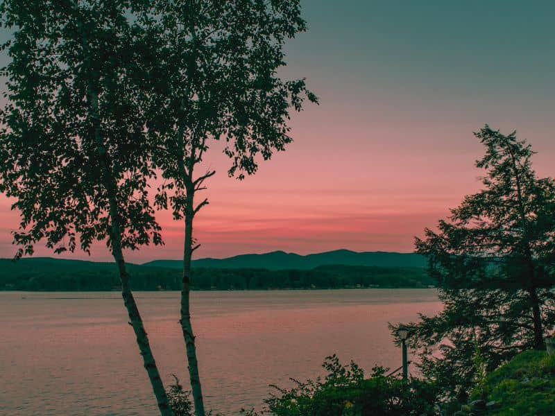Lake Bomoseen in Vermont at blue hour sunset with calm water and glowing sky.